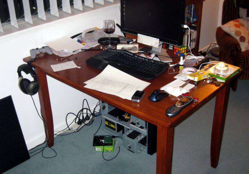 A messy computer desk with the hard disk PCB connected via USB