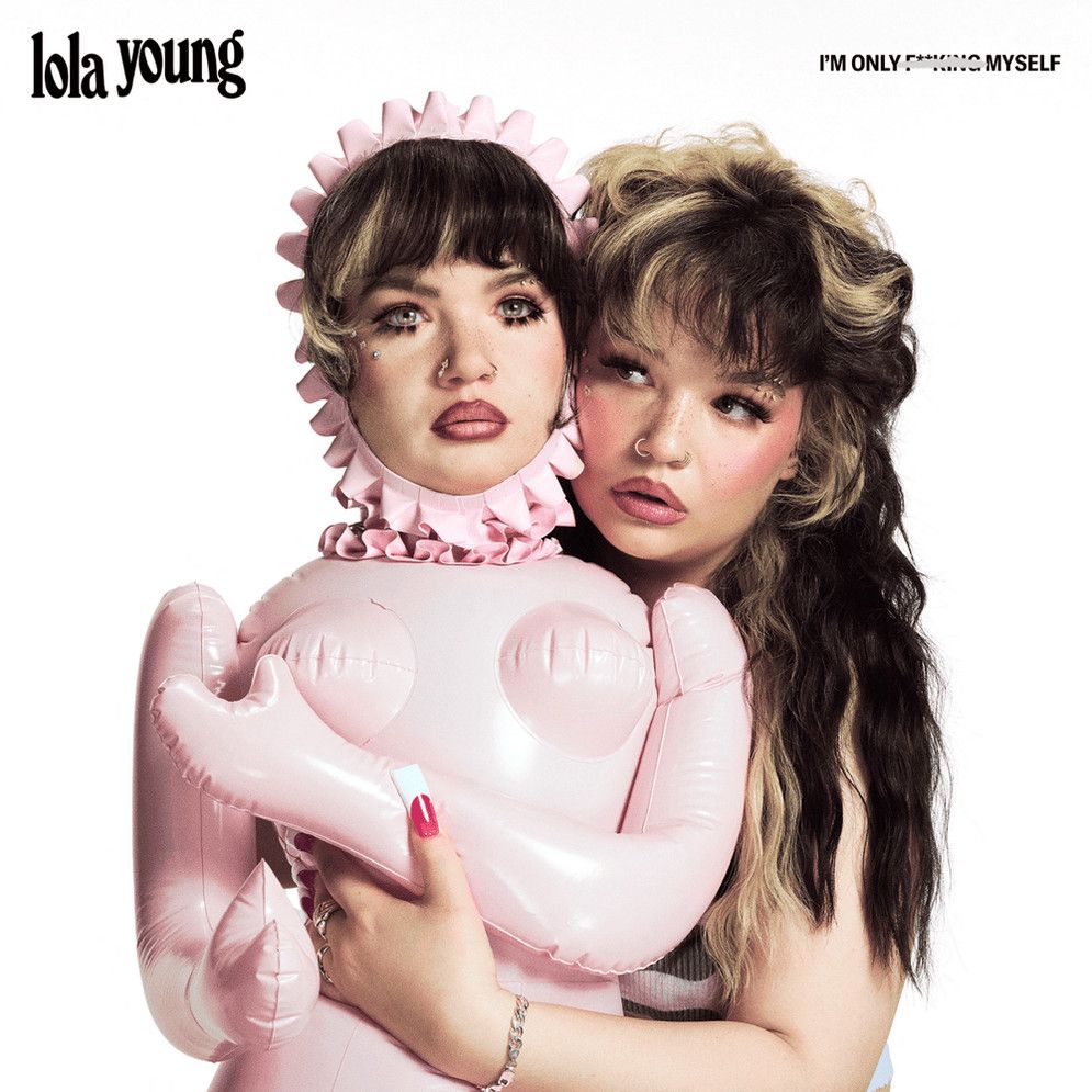 Album cover of I’m only F**cking Myself with Lola Young holding a pink blow-up doll that has her own face